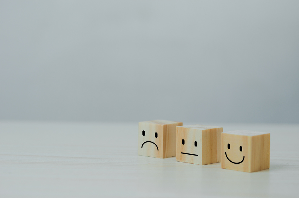 Customer service and Satisfaction concept happy Smiley face icon.Business feedback positive rating very impressed wood cube on table.